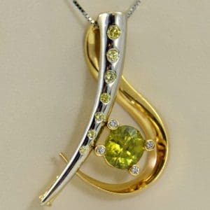 custom designed pin or pendant with sphene and yellow diamonds treble clef.JPG