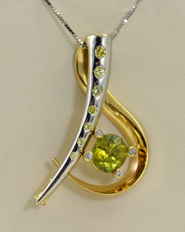 custom designed pin or pendant with sphene and yellow diamonds treble clef.JPG