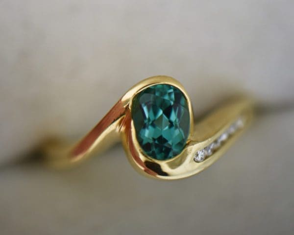 custom 18k yellow gold swirl ring with bezel set teal tourmaline 4