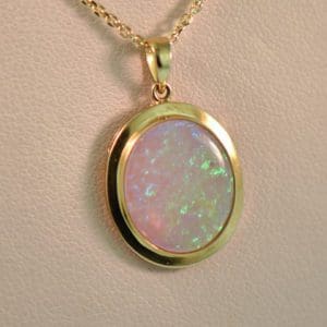 large oval australian crystal opal pendant in yellow gold bezel