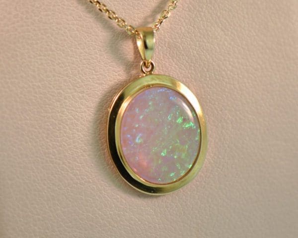 large oval australian crystal opal pendant in yellow gold bezel