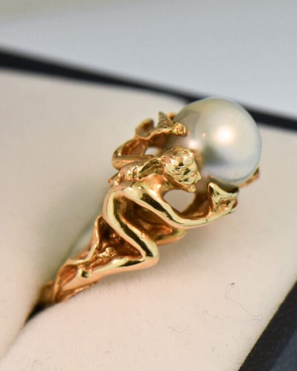 carved artsy gold ring with pixie or sprite holding pearl