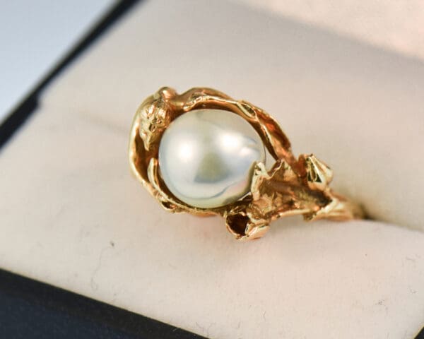 carved artsy gold ring with pixie or sprite holding pearl 2