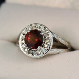 red hessonite garnet and diamond halo ring with carved design